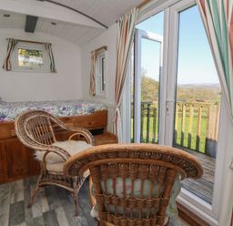 A bedroom with a bed and chairs at Shepherds Delight in Biddulph Moor