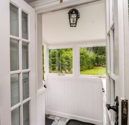 An entryway with a door and windows leading to a garden at 3 Tre Felin Llandygai near Bangor