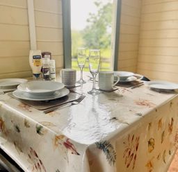 A dining room table set with plates and glasses at Cwt Tyddyn Shepherd's Hut in Corwen