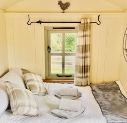 A bedroom with a bed and a window at Cwt Tyddyn Shepherd's Hut in Corwen