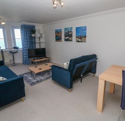 A living room with a tv and seating area at 21 Compass Point in Carbis Bay