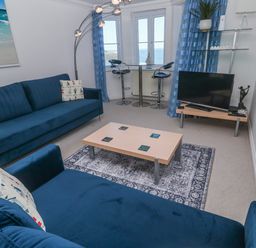 A living room with a sofa, coffee table, and television at 21 Compass Point, Carbis Bay