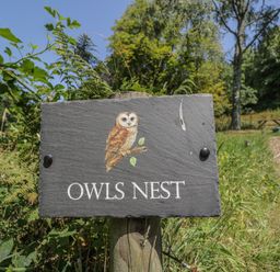 A sign indicating Owls Nest at Owls Nest Lodge in South Molton