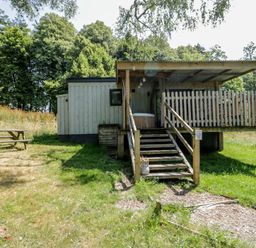 A cabin with a deck and picnic table at Owls Nest Lodge South Molton