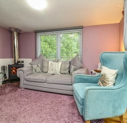 A living room with a sofa and armchair at Hedgehogs Lodge in South Molton