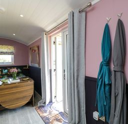 A living room with a bed and a door at Hares Hideaway Shepherd's Hut in South Molton