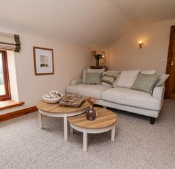 A snug with a sofa and coffee table at Swallow Cottage in Lealholm