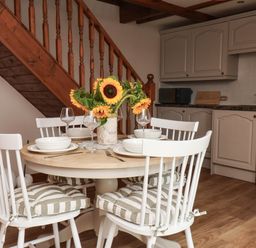 A kitchen with a dining table and chairs at Swallow Cottage in Lealholm