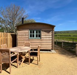 A cabin with a table and chairs outside at The Orchard in Ringstead
