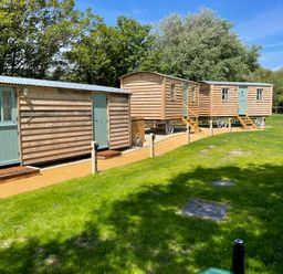 Three wooden caravans in an outdoor area at The Orchard in Ringstead