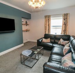 A living room with a sofa and TV at Cuckoo's Nest in Whitby