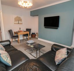 A living room with a sofa and dining table at Cuckoo's Nest in Whitby