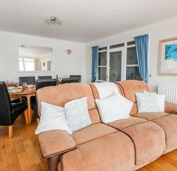 A dining room with a sofa and a dining table at Flat 17 Golden Gates in Poole
