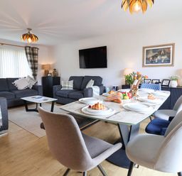 A living room with a dining table and sofa at Seaview in Pakefield