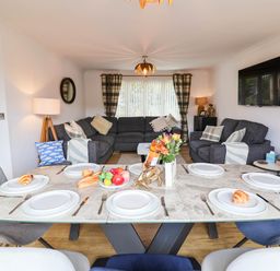 A dining room with a table set for meals at Seaview in Pakefield