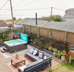 A garden with a hot tub and sitting area at Seaview in Pakefield