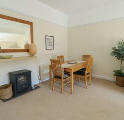 A dining room with a table and chairs at Castle Gardens Apartment in Beaumaris