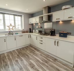 A kitchen with cabinets and appliances at Sugar Loft in Silloth