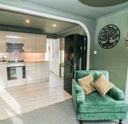 A kitchen with a stove and refrigerator at The Nest Lodge 55 in Grantham