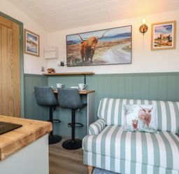 A snug room with a sofa and table in Salt Haven Shepards Hut Pevensey