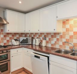 A kitchen with appliances and cabinets at 6 Dartmouth House in Dartmouth