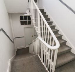 A staircase with a handrail and a door at Time Out in Whitby