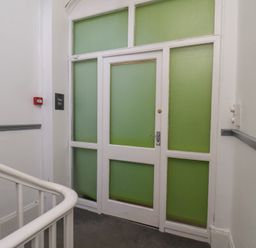 A door with a sign and staircase at Time Out in Whitby