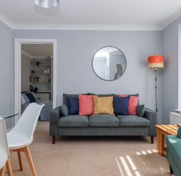 A living room with a sofa and dining table at The Arches in Torquay