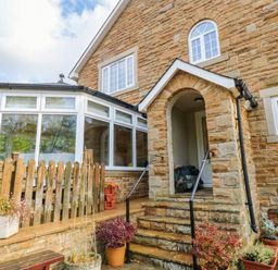 An outdoor view of a house entrance with a garden at Stone Lodge near Haltwhistle