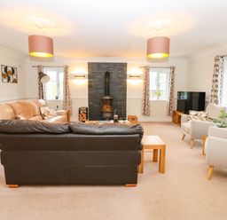 A living room with a sofa and fireplace at Stone Lodge near Haltwhistle