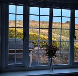 A window view showing a garden and a hill at Stone Lodge near Haltwhistle