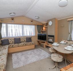 A living room with a sofa and dining table at Ger Y Mor in New Quay