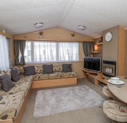 A living room with a sofa and television at Ger Y Mor in New Quay