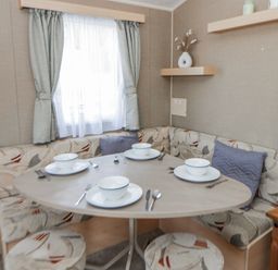 A dining area with a round table and seating at Ger Y Mor in New Quay