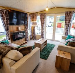 A living room with a sofa and a television at 108 Fox Burrow Hang in Great Yarmouth