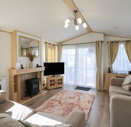 A living room with a television and fireplace at 2 bed Caravan in Stowmarket