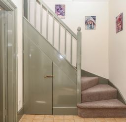 A staircase with photographs on wall at Lukesland Wing Ivybridge