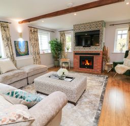 A living room with a fireplace and television at The Coach House near Charminster