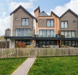 A house with balconies and a fenced yard at 2 Glan Yr Aber in Colwyn Bay