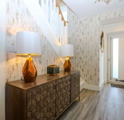 A hallway with lamps and a table at 2 Glan Yr Aber in Colwyn Bay