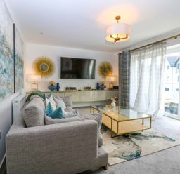A living room with a sofa and television at 2 Glan Yr Aber in Colwyn Bay