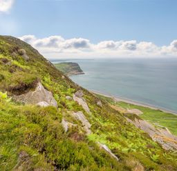 A view of the coast with rocks and greenery at Ty Pen in Nefyn