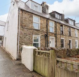 A stone house with windows and a gate at Ty Pen in Nefyn