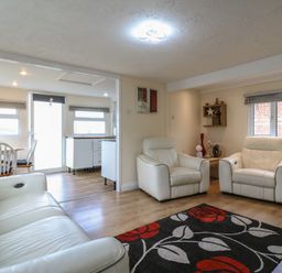 A living room with white chairs and a table at 130 Park Ave Holiday Village