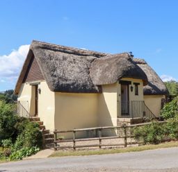 A thatched roof cottage with garden at The Cottage in Sampford Courtenay