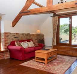 A living room with a sofa and coffee table at The Cottage in Sampford Courtenay