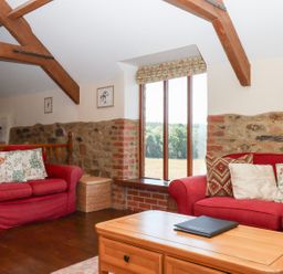 A living room with sofas and a coffee table at The Cottage in Sampford Courtenay