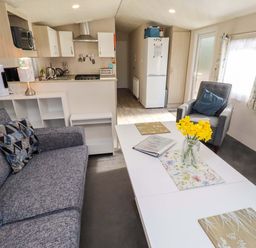 A living room with a sofa and coffee table at Gardeners Lodge