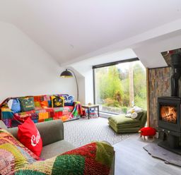 A living room with a sofa and a fireplace at Trwyn Cam in Brynrefail near Llanberis