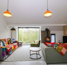 A living room with a sofa and coffee table at Trwyn Cam in Brynrefail near Llanberis